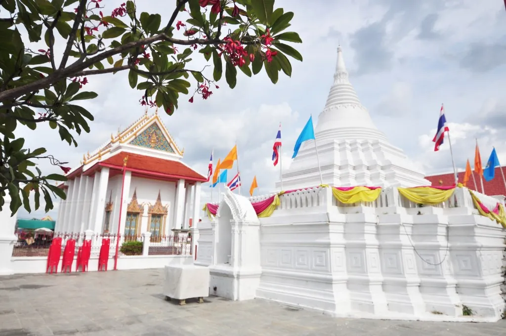 ลานวัดปรมัยยิกาวาส มีเจดีย์สีขาวประดับผ้าเหลืองชมพูอยู่ทางขวา และพระอุโบสถอยู่ด้านหลัง มีธงหลากสีปักรอบลาน